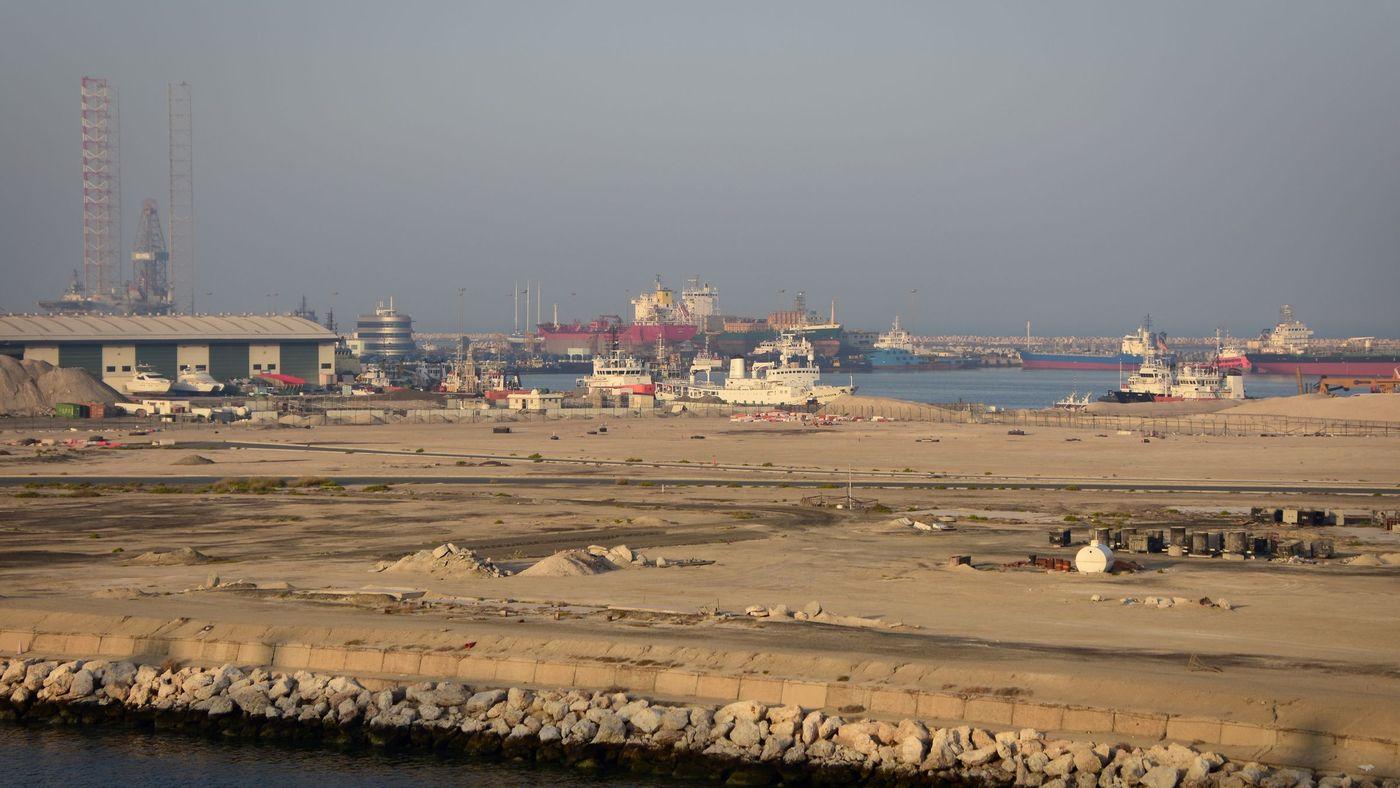 Container cranes and berthed vessels working a commercial terminal at dusk